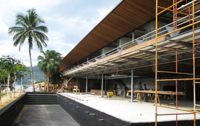 Canteiro de obras com fundação radier e armações de aço, ilustrando as etapas iniciais e fatores que influenciam quanto custa construir uma casa